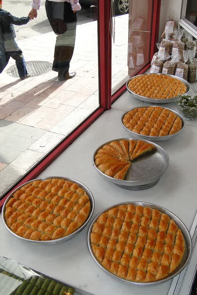 Trays of baklava and mounds of green pistachios for sale at a shop in Gaziantep