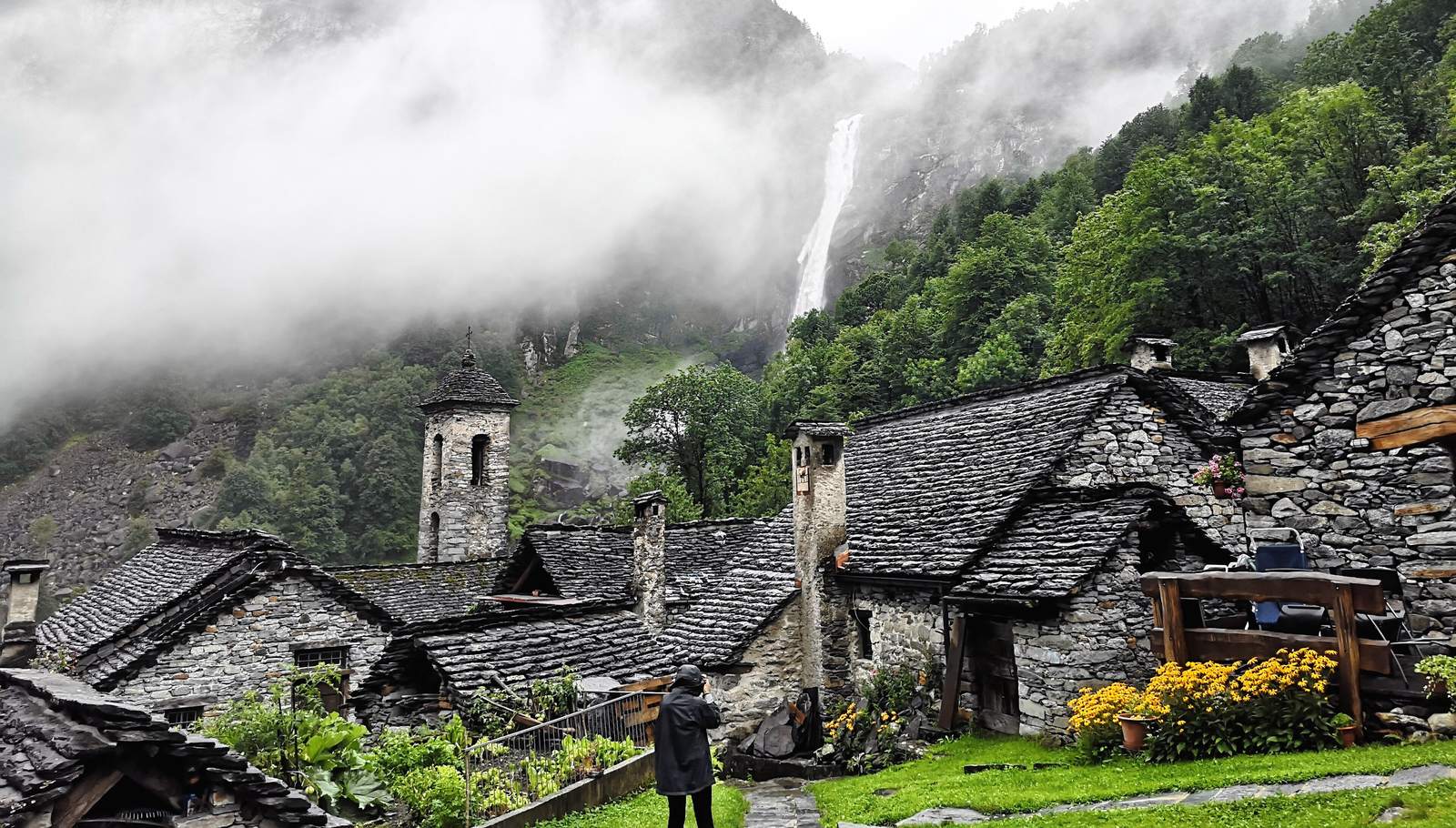 The village of Foroglio in Val Bavona, stone-roofed houses on the valley floor with mountains rising behind